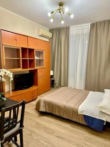 - une chambre avec un lit et une télévision à écran plat dans l'établissement Bicocca Modern Apartment, à Milan