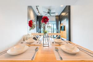 a dining room with a table with red flowers on it at Serene Nova Family Retreat (2-6pax)near Kea Farm Market in Brinchang