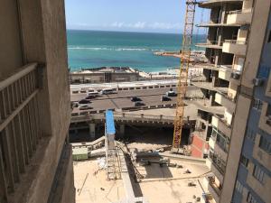 Blick auf ein Gebäude im Bau neben dem Meer in der Unterkunft Elite Sea view in Alexandria
