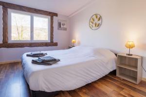 Un dormitorio con una gran cama blanca y una ventana en Le Garage, en Lorp Sentaraille
