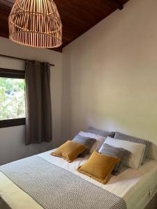 een slaapkamer met een bed met 2 kussens erop bij Casa Hibiscus in Ilha de Boipeba