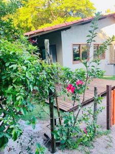 een klein huis met een boom met roze bloemen bij Casa Hibiscus in Ilha de Boipeba