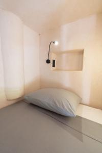a bed in a small room with a lamp at Secret Beach Hostel in Puerto Escondido