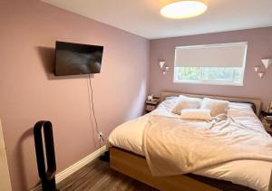 Schlafzimmer mit einem Bett mit weißer Bettwäsche und einem Fenster in der Unterkunft Ocean Villa -1BDR- King bed- Kitsilano beach w/parking in Vancouver