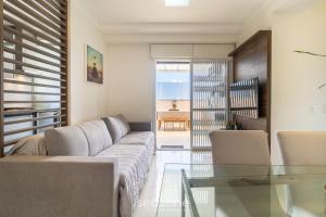 un soggiorno con divano e tavolo in vetro di Lindo apto confortável e bem localizado MOS104 a Florianópolis