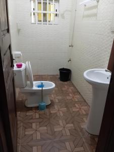 y baño con aseo y lavamanos. en Superbe Appartement COTONOU Place de L'étoile rouge, en Cotonou
