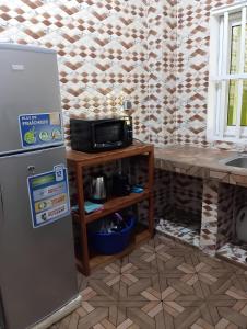 cocina con nevera y mesa con microondas en Superbe Appartement COTONOU Place de L'étoile rouge, en Cotonou