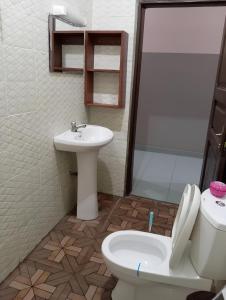 y baño con aseo y lavamanos. en Superbe Appartement COTONOU Place de L'étoile rouge, en Cotonou