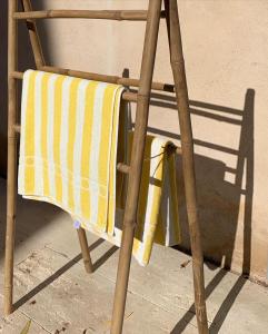uma cadeira de madeira com uma toalha amarela e branca em Le Domaine de l'Aiguille Alpilles, Eygalières, Saint Rémy de Provence em Orgon