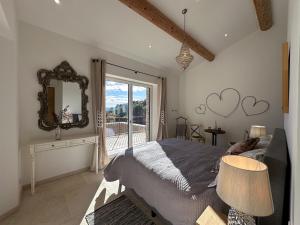 - une chambre avec un lit, un miroir et une fenêtre dans l'établissement Mas La Rose Sauvage - magnificent Luberon views, à Murs