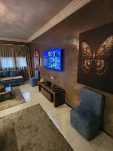 a living room with a butterfly painting on the wall at Aprt 4 Family in Marrakech