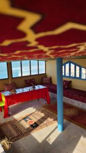 een kamer met een tafel en een rode luifel bij Suerte Loca in Sidi Ifni