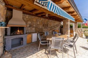 a patio with a fireplace and a table and chairs at Villa Zaria by Briskva in Mošćenička Draga