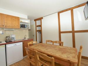 eine Küche mit einem Holztisch sowie einem Tisch und Stühlen in der Unterkunft Appartement Chamrousse, 3 pièces, 6 personnes - FR-1-549-78 in Chamrousse