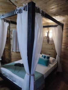 Schlafzimmer mit Himmelbett und weißen Vorhängen in der Unterkunft Casa na Árvore - Chalé Quemeninho in Apiaí