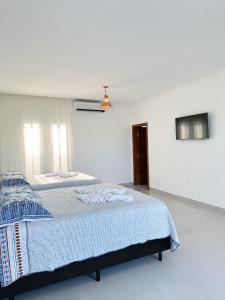 biała sypialnia z łóżkiem z niebieskim kocem w obiekcie CASA AL MARE w mieście Prado