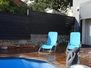 two blue chairs sitting next to a swimming pool at Guerras House in Porto