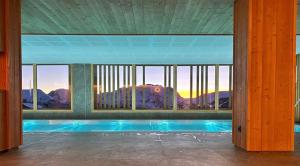 a swimming pool in a building with a view of a mountain at La Terrasse de l Alpe d Huez in L'Alpe-d'Huez
