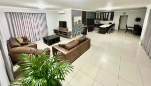 a large living room with couches and a piano at Crossroads Luxury Accommodation in Swakopmund