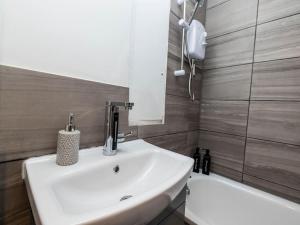 a bathroom with a sink and a mirror and a tub at Pristine Relocation Flat 2 in London