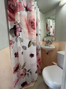 La salle de bains est pourvue d'un rideau de douche et de fleurs. dans l'établissement MamZelle TouTapié Coeur de Vannes, à Vannes