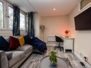 a living room with a couch and a desk at Pristine Relocation Flat 2 in London