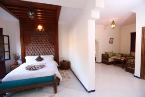 1 dormitorio con 1 cama grande y cabecero de madera en Kasbah Tizimi en Erfoud
