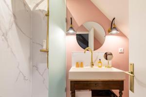 La salle de bains est pourvue d'un lavabo et d'un miroir. dans l'établissement Chez Camille, à Arnay-le-Duc