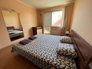 a bedroom with a bed and a large window at Lovely spacious 3BR just outside of city centre in Sofia