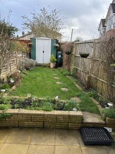 a backyard with a garden with a fence at Cosy Corner - 2 beds, free parking, garden, 2 mins walk to Southampton General Hospital in Southampton