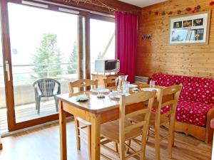 a dining room with a table and chairs and a couch at Appartement 3* avec terrasse plein sud, proche pistes et commerces à Chamrousse - FR-1-549-92 in Chamrousse