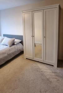 a bedroom with a bed and a glass closet at Two bed Apartment free parking near Colindale Station in Colindale