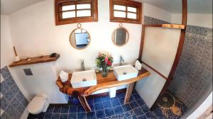 a bathroom with two sinks and a toilet at Fare Oviri Lodge in Opoa