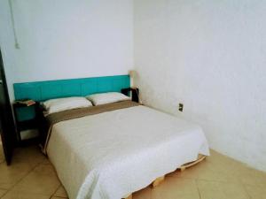 a bedroom with a bed with a blue headboard at El Bosque +598 94625953 in Parque del Plata