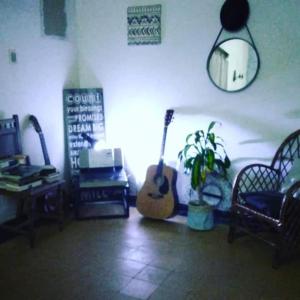 una habitación con guitarras, una planta y un espejo en El Bosque +598 94625953 en Parque del Plata