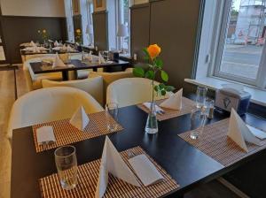 a dining room with tables and chairs with white napkins at Videbæk Hotel in Videbæk