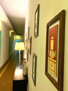 拉弗洛雷斯塔的住宿－Hotel Vista La Floresta，墙上挂有画作的走廊和一盏灯
