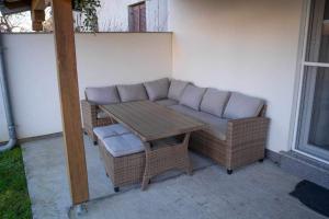 a patio with a couch and a table and chairs at Kuća za odmor PAVIĆ in Vinkovci