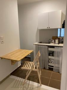 uma mesa de madeira e uma cadeira numa pequena cozinha em Joli studio centre historique et au calme (2) em Montpellier
