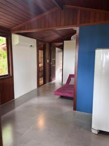 sala de estar con pared azul y alfombra roja en Casa do João, en Isla de Boipeba