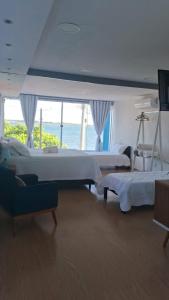 a bedroom with two beds and a view of the ocean at Pousada belo sol in São Pedro da Aldeia