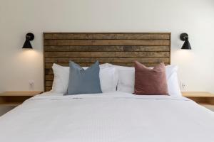 una camera con letto bianco e cuscini di Pinewood 102 Inn At Old Beach a Virginia Beach