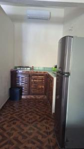 una cocina con nevera de acero inoxidable y armarios de madera en Chuchosmom room 3, en Temalhuacán