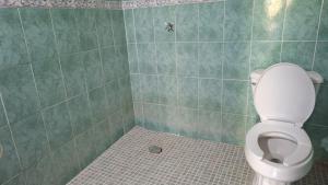 a bathroom with a toilet and a tiled floor at Chuchosmom room 3 in Temalhuacán