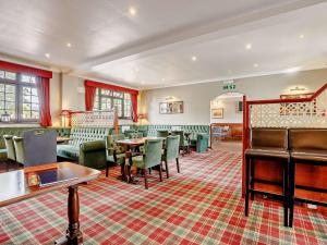 um restaurante com cadeiras verdes e mesas num quarto em 2 Bed in Mablethorpe 93143 em Trusthorpe