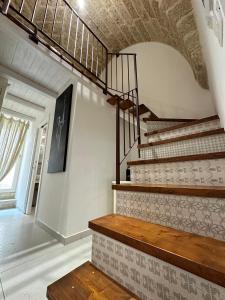 a staircase in a house with a stair case at Palazzo Alma luxury rooms in Casarano