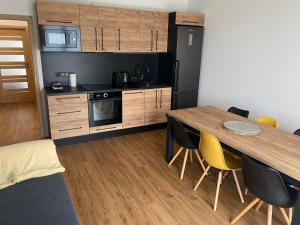 a kitchen with a wooden table and yellow chairs at #1 U Lanovky in Červená Voda