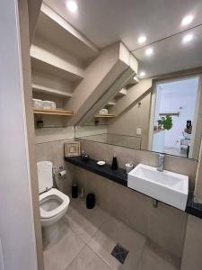 une salle de bain avec toilettes, lavabo et miroir dans l'établissement San Isidro Luz y Verde, à San Isidro