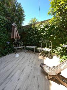 - une terrasse avec 2 bancs et un parasol dans l'établissement San Isidro Luz y Verde, à San Isidro