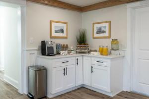 uma cozinha com armários brancos e um micro-ondas em Pinewood 102 Inn At Old Beach em Virginia Beach